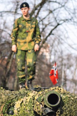 Vilnius, Litvanya - 16 Şubat 2022: Norveç Ordusu zırhlı tankı üzerinde asker ve Norveç bayrağı bulunan top ve kamuflaj zırhı