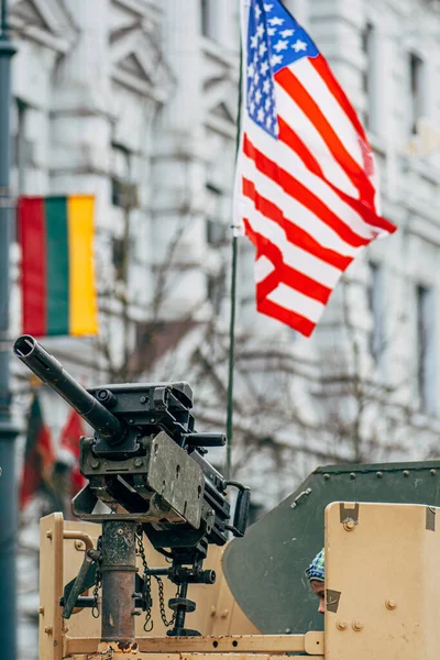 Machine gun on a tank or military vehicle with American and Lithuanian flag, Lithuania, USA or US army, vertical