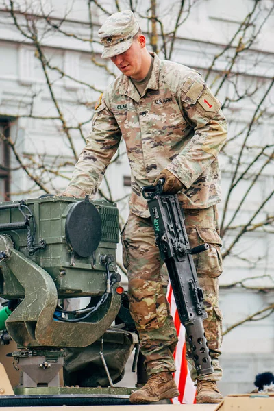 Vilnius, Litvanya - 16 Şubat 2022: Amerikan bayrağı taşıyan bir makineli tüfeğin tepesinde ABD Deniz Piyade Birliği askeri, eğitime ya da savaşa hazırdır.