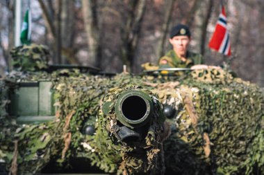 Vilnius, Litvanya - 16 Şubat 2022: Norveç Ordusu zırhlı tankı, üzerinde asker ve Norveç bayrağı bulunan kamuflaj zırhı