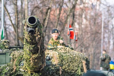 Vilnius, Litvanya - 16 Şubat 2022: Norveç Ordusu zırhlı tankı ve üzerinde asker ve Norveç ve Ukrayna bayrağı bulunan kamuflaj teçhizatı, NATO müdahale gücü