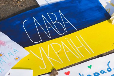 Ukrayna bayraklarıyla Ukrayna 'yı destekleyen Putin ve Rusya, savaşa karşı barışçıl bir gösteri sırasında pankartlar. Savaşı Durdur