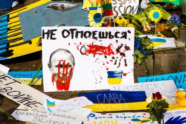 Ukrayna bayraklarıyla Ukrayna 'yı destekleyen Putin ve Rusya, savaşa karşı barışçıl bir gösteri sırasında pankartlar. Savaşı Durdur