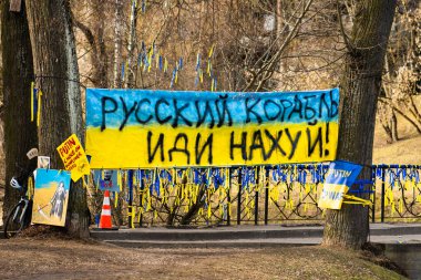 Ukrayna bayraklarıyla Ukrayna 'yı destekleyen Putin ve Rusya, savaşa karşı barışçıl bir gösteri sırasında pankartlar. Savaşı Durdur