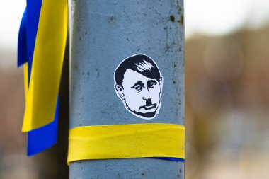 Savaşa, Putin 'e ve Rusya' ya ve Ukrayna 'ya karşı barışçıl bir gösteri sırasında Ukrayna renklerine sahip kurdeleler