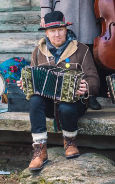 Rumsiskes, Litvanya - 26 Şubat 2022: Rumsiskes, Litvanya 'da Paskalya' dan yedinci hafta önce düzenlenen bir Litvanya halk festivali olan Uzgavenes sırasında akordiyon çalan geleneksel müzisyen