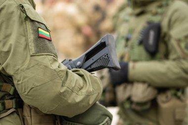 Vilnius, Litvanya - 29 Mart 2022: Litvanya Bayrağı, Litvanya Silahlı Kuvvetleri Tüfekli veya tüfekli bir asker üniforması, NATO ile bütünleşme birimi, yakın plan