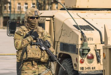 ABD - 29 Mart 2022: Yüzü ve güneş gözlükleriyle kaplı ABD Deniz Piyade Birliği askeri, av tüfeği ve zırhlı araç Humvee, ABD veya ABD ordusu askerleri savaşa, tatbikata veya savaşa hazır