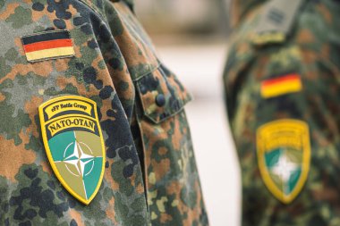 Berlin, Almanya - 29 Mart 2022: Almanya bayrağı ve NATO savaş grubunun bir asker üniforması üzerindeki sembolü