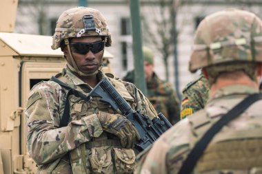 ABD - 29 Mart 2022: Güneş gözlüklü, tüfekli ve zırhlı araç Humvee 'li Afro-Amerikan Deniz Piyade Kolordusu askeri, tatbikat veya savaşa hazır.