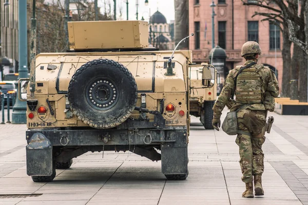 Vilnius, Litvanya - 29 Mart 2022: ABD Deniz Piyadeleri askerleri silah, miğfer ve zırhlı araçlara sahip Humvee, ABD veya ABD ordusu birlikleri kentte tatbikat veya savaşa hazır