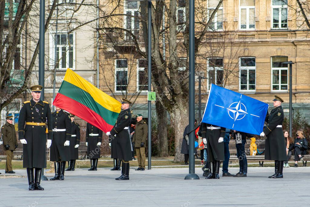 Vilnius, Lithuania - March 29 2022: Flags and symbols of NATO and Lithuania, NATO force integration unit, during a ceremony with soldiers