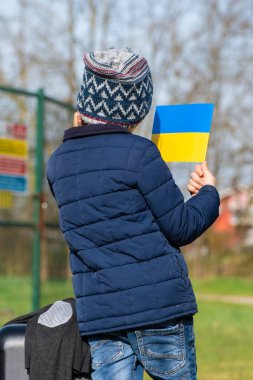 Ukrayna 'daki savaş sırasında Putin ve Rusya, mülteci kampı, dikey mülteci kampı ve Ukrayna bayrağı taşıyan çocuk ya da çocuk.