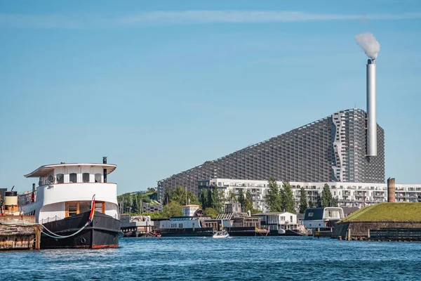 Amager Bakke, Slope or Copenhill, incineration plant, heat and power waste-to-energy plant and recreational facility in the district of Amager, Copenhagen, Denmark, with modern buildings and boats