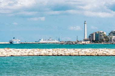 Bari, Puglia, Italy - August 29 2021: Bari port or harbor with breakwater, cruise ships and lighthouse on background