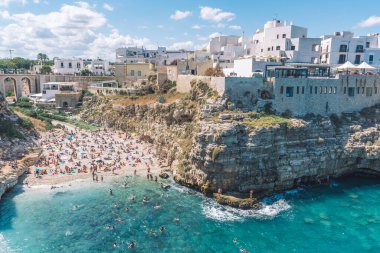 Polignano a Mare, Puglia, İtalya - 30 Ağustos 2021: Beyaz taş evler, uçurum, sahil, mavi deniz ve Akdeniz doğası ile çevrili güzel Polignano a Mare manzarası