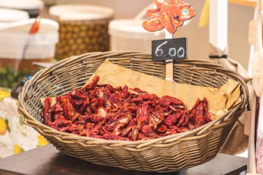 Bari 'deki bir markette hasır sepetin içinde güneşte kurutulmuş kırmızı domatesler. Yaklaş. Olgun domatesler kurutma zamanlarının çoğunu güneşte geçirdikten sonra su kaynaklarının çoğunu kaybederler.