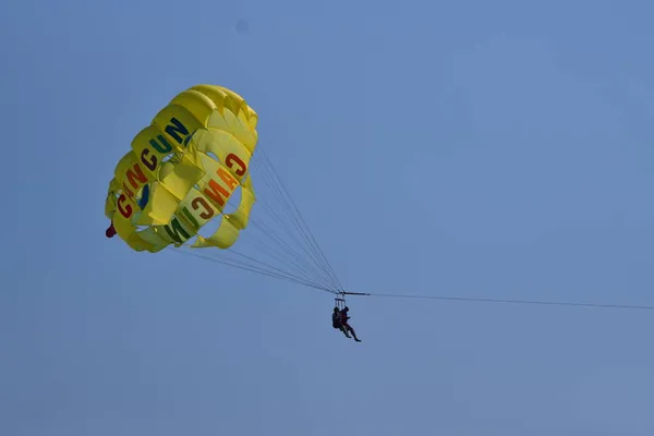 Close de um homem pulando de paraquedas perto do solo com um