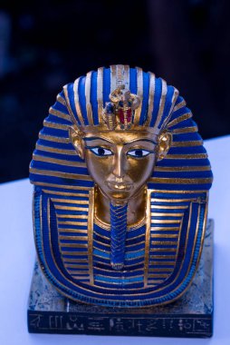 Tutankamon Maskesi 'ni temsil eden seramik hatıra Mısır Firavunu Tutankamon' un altın maskesi. Howard Carter tarafından 1925 yılında Krallar Vadisi 'nde keşfedilmiş ve şu anda Kahire' deki Mısır Müzesi 'nde sergilenmektedir..