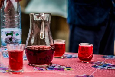 Isabela veya Capsunica sarmaşıkları ile bardaklar ve sürahiler berrak pembe, şarap mahzeni sıcaklığında soğuk yaz mevsiminde fıçıdan çıkarılır. 