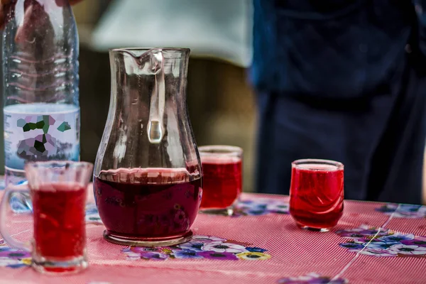 Isabela veya Capsunica sarmaşıkları ile bardaklar ve sürahiler berrak pembe, şarap mahzeni sıcaklığında soğuk yaz mevsiminde fıçıdan çıkarılır. 