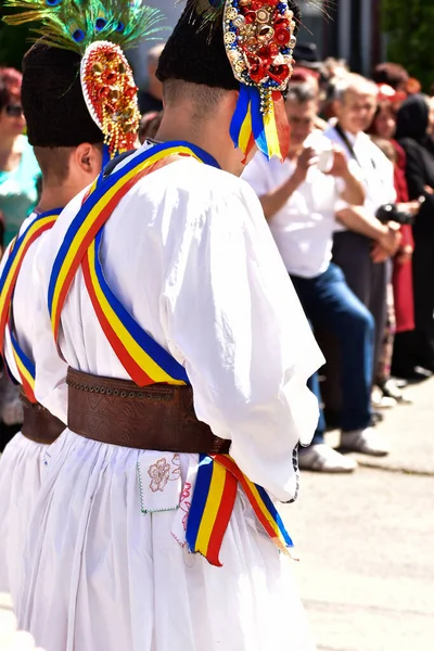 トランシルヴァニアの民俗舞踊家は 孔雀のビーズや羽 白いリネンのシャツやパンツ ワイドレザーベルト 国旗を表す三色の斜線で飾られたAstrakhanラムスキンの帽子を着用してください — ストック写真