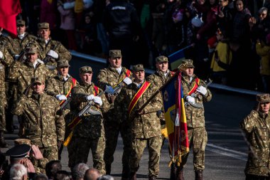 Romanya 'nın Targu-jiu' daki ulusal günü, gala üniformaları ve otomatik silah ve maskeleme kıyafetleriyle donatılmış Romen kara kuvvetleri askerleriyle geçit töreni düzenledi.