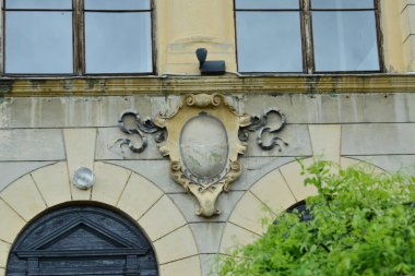 Romen ortaçağ mimari tarzı yarı dairesel kemerler, güçlendirilmiş duvarlar, mazgallı duvarlar, ahşap kepenkli pencereler, levrek yatakları, diğer kabartmalar, kale veya şehir arması ile karakterize ediliyor