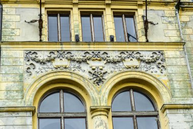 Romen ortaçağ mimari tarzı yarı dairesel kemerler, güçlendirilmiş duvarlar, mazgallı duvarlar, ahşap kepenkli pencereler, levrek yatakları, diğer kabartmalar, kale veya şehir arması ile karakterize ediliyor