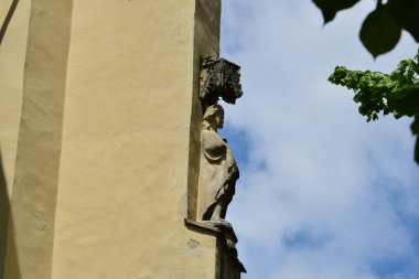 Romen ortaçağ mimari tarzı yarı dairesel kemerler, güçlendirilmiş duvarlar, mazgallı duvarlar, ahşap kepenkli pencereler, levrek yatakları, diğer kabartmalar, kale veya şehir arması ile karakterize ediliyor