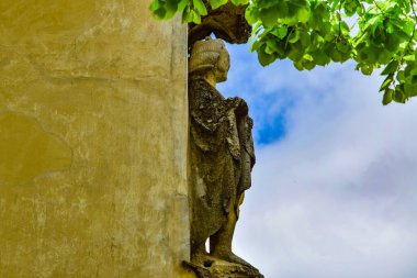 Romen ortaçağ mimari tarzı yarı dairesel kemerler, güçlendirilmiş duvarlar, mazgallı duvarlar, ahşap kepenkli pencereler, levrek yatakları, diğer kabartmalar, kale veya şehir arması ile karakterize ediliyor