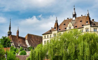 Sighisoara Kalesi 'ndeki ortaçağ binaları laik evler, tarihi anıtlar, her birinin adı, tarihi ve plaketleri Rumen İngilizcesi ve Almancası sokak ve binaları.