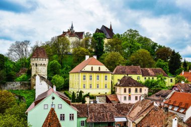 Sighisoara Kalesi 'ndeki ortaçağ binaları laik evler, tarihi anıtlar, her birinin adı, tarihi ve plaketleri Rumen İngilizcesi ve Almancası sokak ve binaları.