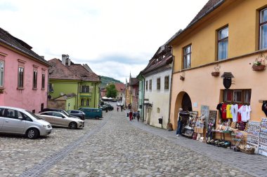 Sighisoara Kalesi 'ndeki ortaçağ binaları laik evler, tarihi anıtlar, her birinin adı, tarihi ve plaketleri Rumen İngilizcesi ve Almancası sokak ve binaları.