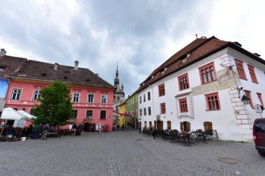 Sighisoara Kalesi 'ndeki ortaçağ binaları laik evler, tarihi anıtlar, her birinin adı, tarihi ve plaketleri Rumen İngilizcesi ve Almancası sokak ve binaları.