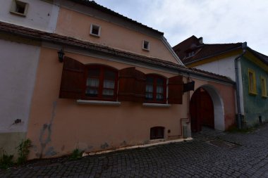 Sighisoara Kalesi 'ndeki ortaçağ binaları laik evler, tarihi anıtlar, her birinin adı, tarihi ve plaketleri Rumen İngilizcesi ve Almancası sokak ve binaları.