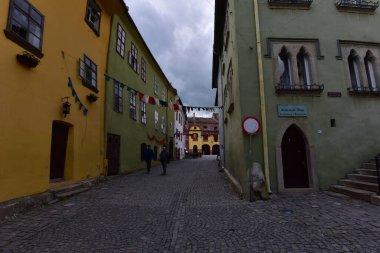 Sighisoara Kalesi 'ndeki ortaçağ binaları laik evler, tarihi anıtlar, her birinin adı, tarihi ve plaketleri Rumen İngilizcesi ve Almancası sokak ve binaları.