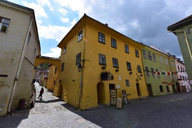 Sighisoara Kalesi 'ndeki ortaçağ binaları laik evler, tarihi anıtlar, her birinin adı, tarihi ve plaketleri Rumen İngilizcesi ve Almancası sokak ve binaları.