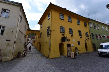 Sighisoara Kalesi 'ndeki ortaçağ binaları laik evler, tarihi anıtlar, her birinin adı, tarihi ve plaketleri Rumen İngilizcesi ve Almancası sokak ve binaları.