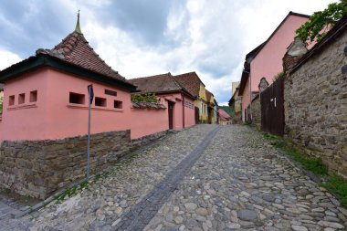 Sighisoara Kalesi 'ndeki ortaçağ binaları laik evler, tarihi anıtlar, her birinin adı, tarihi ve plaketleri Rumen İngilizcesi ve Almancası sokak ve binaları.