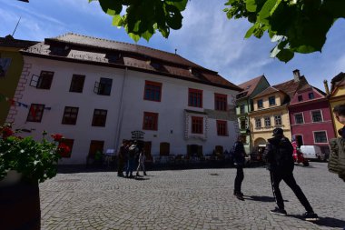 Sighisoara Kalesi 'ndeki ortaçağ binaları laik evler, tarihi anıtlar, her birinin adı, tarihi ve plaketleri Rumen İngilizcesi ve Almancası sokak ve binaları.