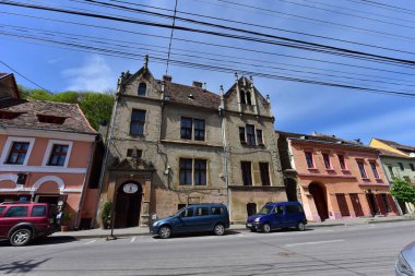 Sighisoara Kalesi 'ndeki ortaçağ binaları laik evler, tarihi anıtlar, her birinin adı, tarihi ve plaketleri Rumen İngilizcesi ve Almancası sokak ve binaları.