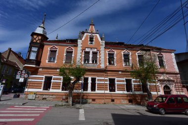 Sighisoara Kalesi 'ndeki ortaçağ binaları laik evler, tarihi anıtlar, her birinin adı, tarihi ve plaketleri Rumen İngilizcesi ve Almancası sokak ve binaları.