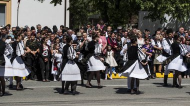 Geleneksel siyah motiflerle dikilmiş ulusal keten pastoral kostümlü Romen halk dansçıları, geleneksel siyah şapka giyen erkekler ve püsküllü siyah fular giyen kadınlar
