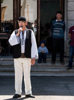Halk sanatçıları Novaci Romanya 'da geleneksel siyah motiflerle dikilmiş keten kumaştan yapılmış ulusal pastoral kostümlerle halk müziği yapıyorlar. Erkekler geleneksel siyah şapka takıyor ve kadınlar püsküllü siyah püsküller giyiyor.