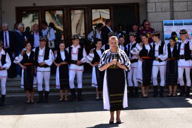 Geleneksel siyah motiflerle dikilmiş ulusal keten pastoral kostümlü Romen halk dansçıları, geleneksel siyah şapka giyen erkekler ve püsküllü siyah fular giyen kadınlar