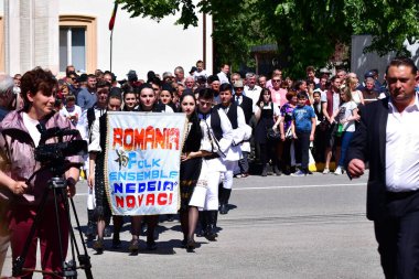 Geleneksel siyah motiflerle dikilmiş ulusal keten pastoral kostümlü Romen halk dansçıları, geleneksel siyah şapka giyen erkekler ve püsküllü siyah fular giyen kadınlar