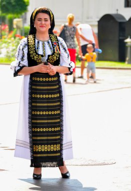 Halk sanatçıları Novaci Romanya 'da geleneksel siyah motiflerle dikilmiş keten kumaştan yapılmış ulusal pastoral kostümlerle halk müziği yapıyorlar. Erkekler geleneksel siyah şapka takıyor ve kadınlar püsküllü siyah püsküller giyiyor.