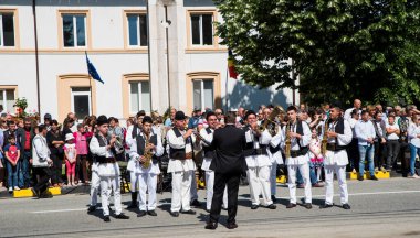 Geleneksel siyah motiflerle dikilmiş ulusal keten pastoral kostümlü Romen halk dansçıları, geleneksel siyah şapka giyen erkekler ve püsküllü siyah fular giyen kadınlar