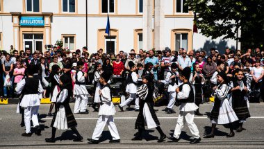 Geleneksel siyah motiflerle dikilmiş ulusal keten pastoral kostümlü Romen halk dansçıları, geleneksel siyah şapka giyen erkekler ve püsküllü siyah fular giyen kadınlar
